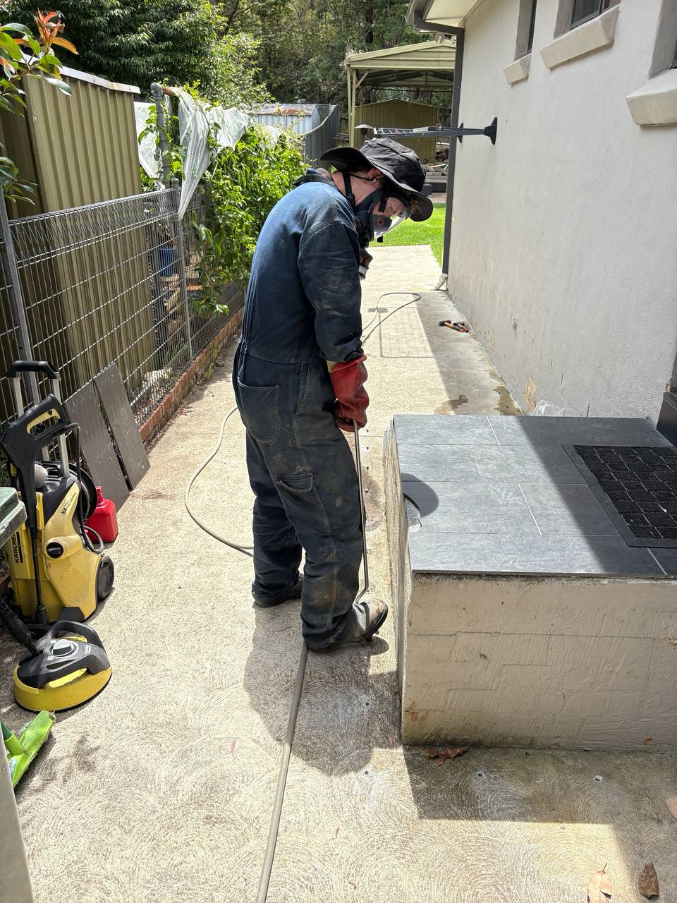 Jason applying termite treatment along an exterior wall in the Blue Mountains